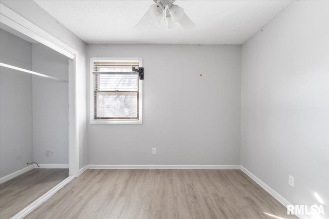 unfurnished bedroom with ceiling fan, a textured ceiling, light wood-type flooring, and a closet