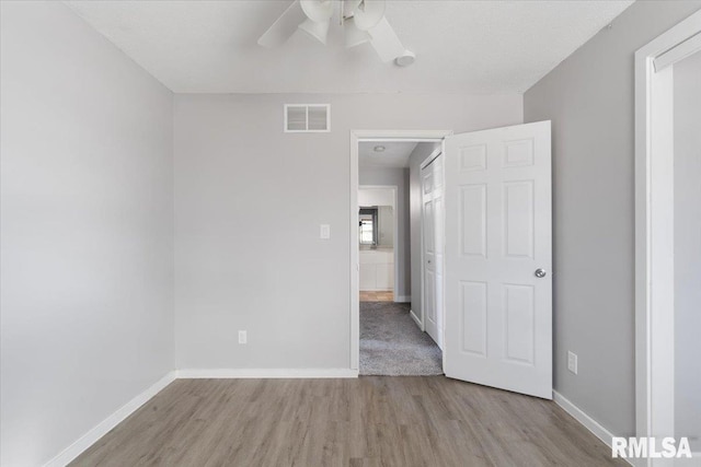 empty room featuring ceiling fan and light wood-type flooring