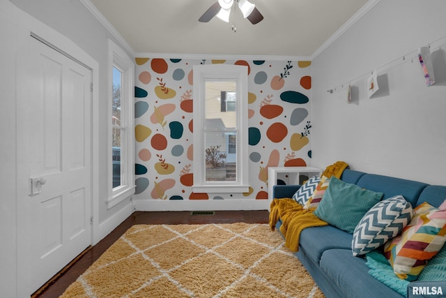 rec room featuring ornamental molding, dark wood-type flooring, and ceiling fan