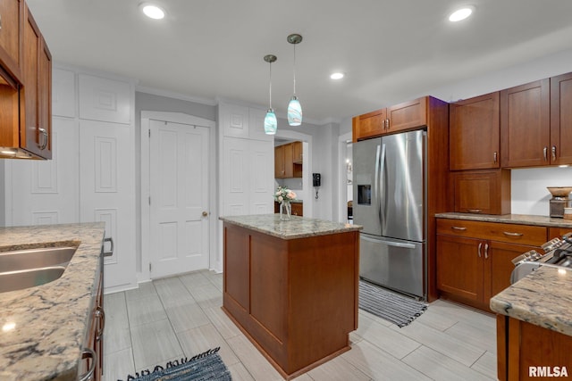 kitchen featuring decorative light fixtures, a center island, stainless steel fridge with ice dispenser, and light stone countertops