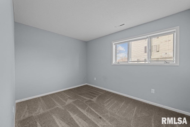 carpeted empty room featuring a textured ceiling