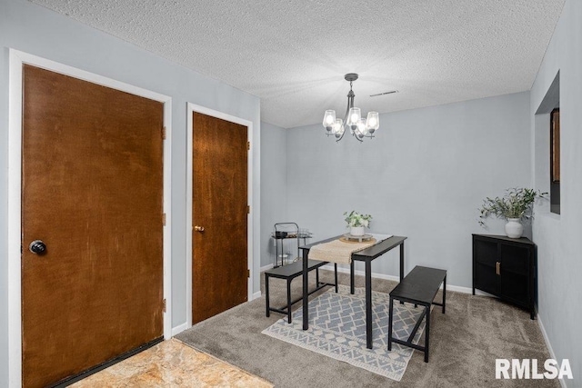 dining area with carpet, a textured ceiling, and a chandelier