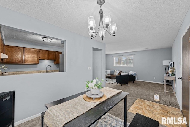 carpeted dining room with sink and a textured ceiling