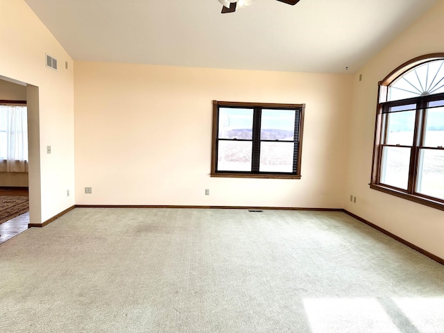 unfurnished room with vaulted ceiling, light colored carpet, and ceiling fan