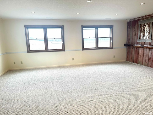 empty room with carpet flooring and a textured ceiling