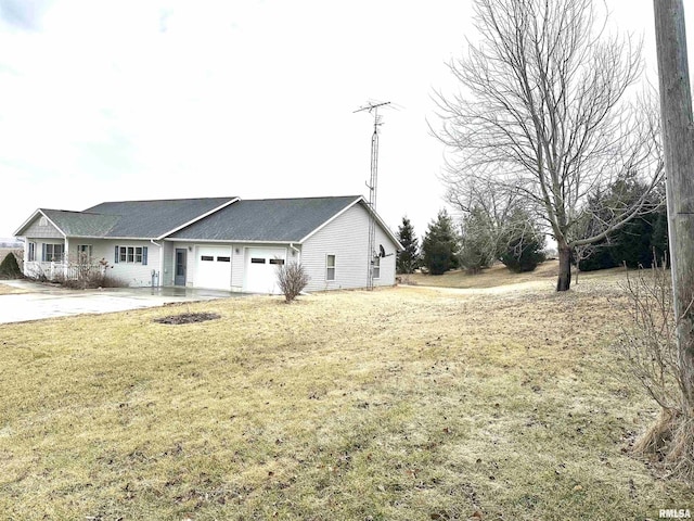 view of side of property with a garage and a lawn