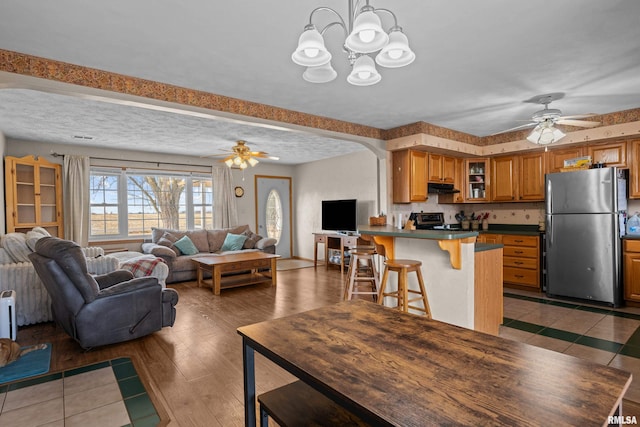 kitchen featuring dark hardwood / wood-style floors, stainless steel appliances, a kitchen breakfast bar, and a textured ceiling