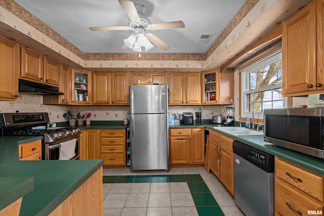 kitchen with stainless steel appliances, sink, light tile patterned floors, and ceiling fan