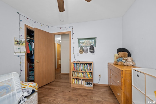 sitting room with ceiling fan and wood-type flooring