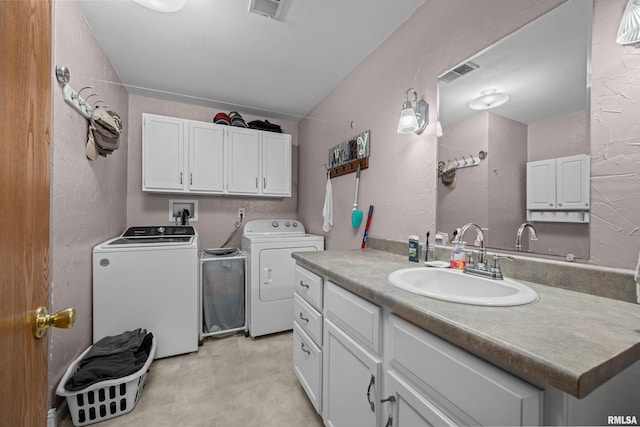 laundry area with cabinets, separate washer and dryer, and sink