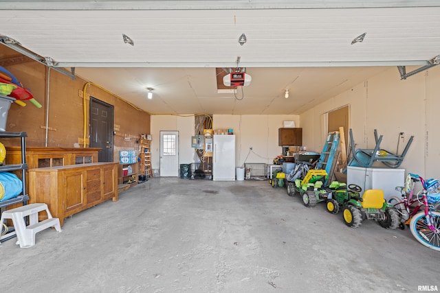 garage featuring a garage door opener and white fridge