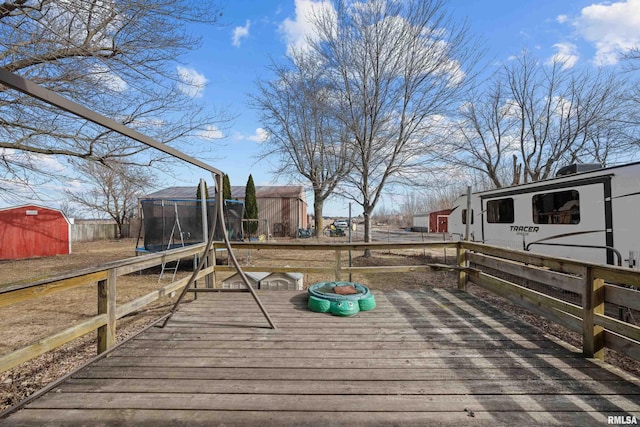 wooden terrace with a trampoline and a storage unit