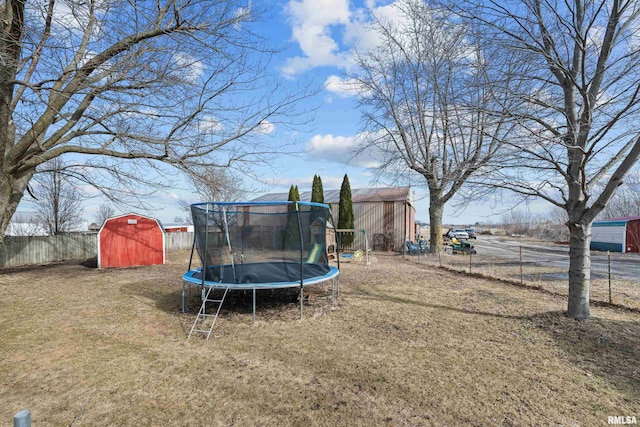 view of yard featuring a trampoline and a storage unit