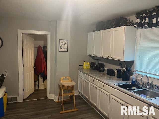 kitchen with sink, dark wood-type flooring, and white cabinets