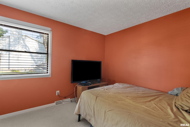 bedroom with carpet floors and a textured ceiling