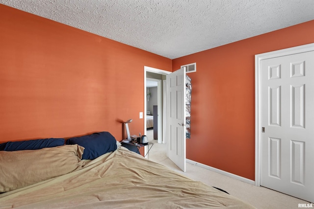 bedroom featuring carpet and a textured ceiling