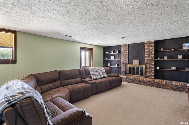 carpeted living room featuring a brick fireplace, a textured ceiling, and built in shelves