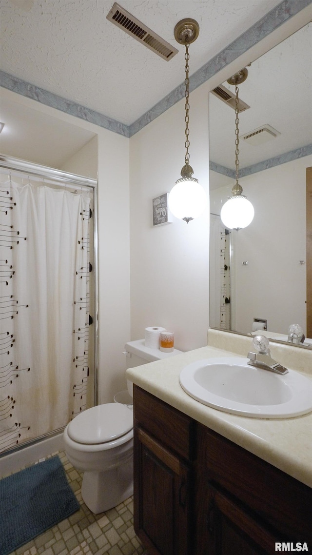 bathroom featuring a shower with curtain, vanity, a textured ceiling, and toilet