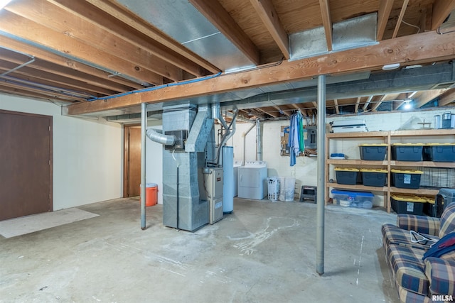 basement with washer and clothes dryer, heating unit, and gas water heater