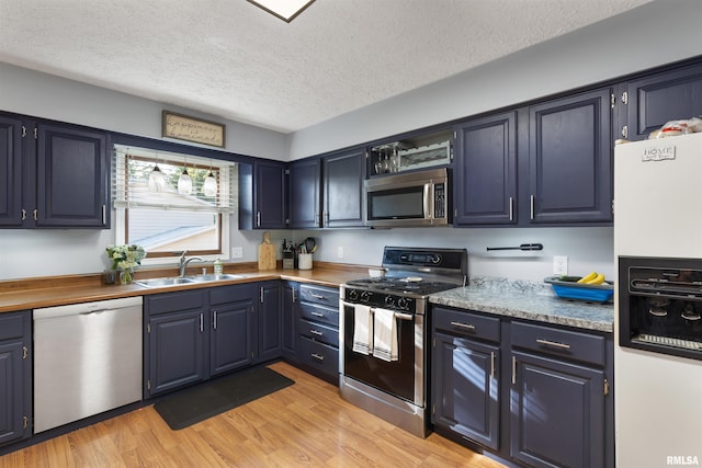 kitchen featuring sink, light hardwood / wood-style flooring, stainless steel appliances, and blue cabinetry