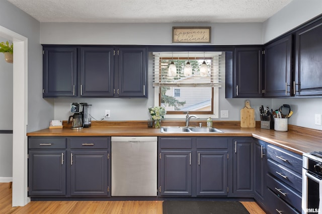 kitchen featuring dishwasher, butcher block counters, sink, and a textured ceiling