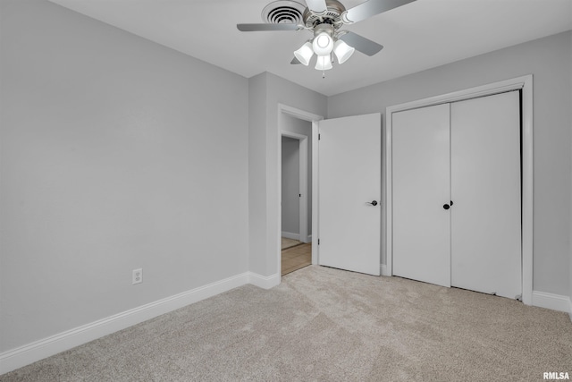 unfurnished bedroom with light colored carpet, ceiling fan, and a closet