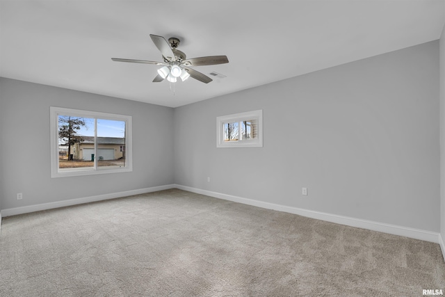 carpeted empty room with plenty of natural light and ceiling fan