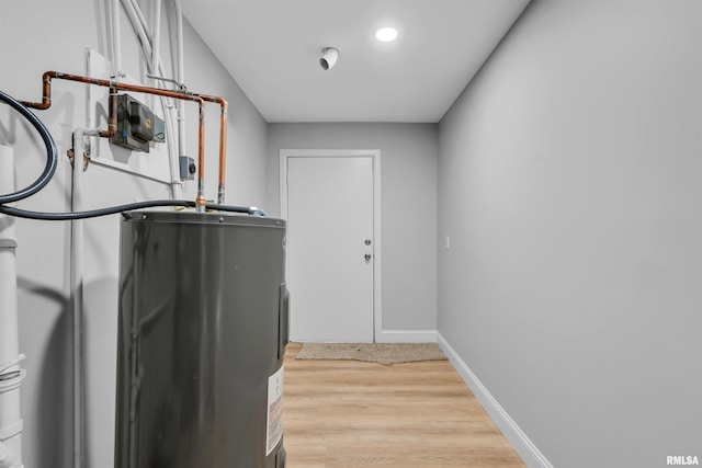 laundry area with water heater and light wood-type flooring