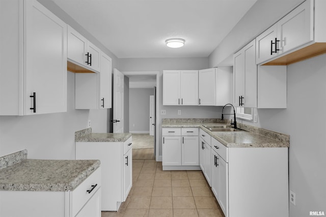 kitchen featuring white cabinetry, sink, and light tile patterned floors