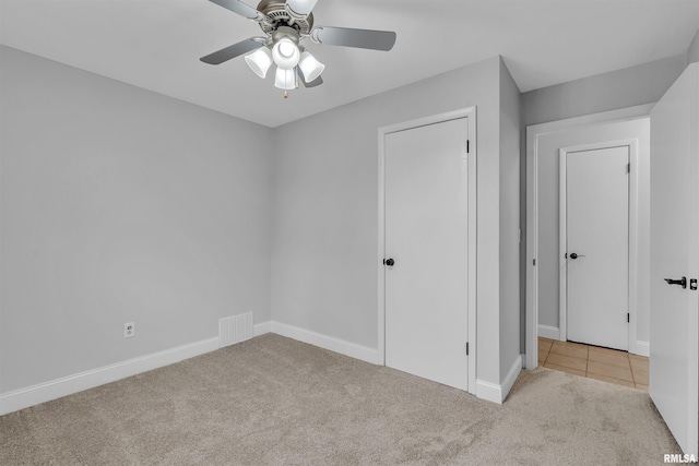 unfurnished bedroom featuring light carpet and ceiling fan