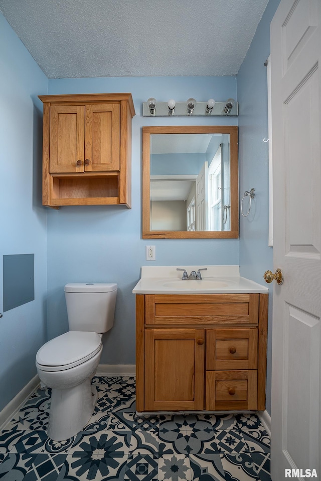 bathroom featuring vanity, toilet, and a textured ceiling