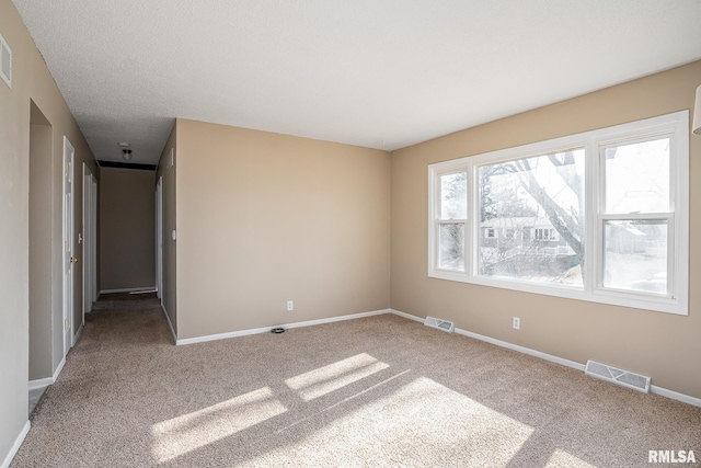 carpeted empty room with a textured ceiling