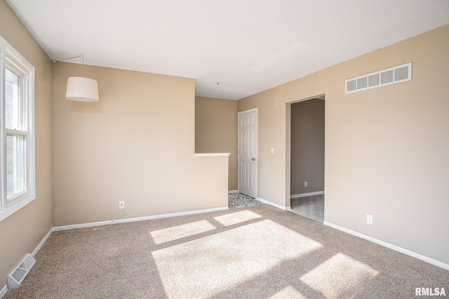 carpeted empty room with a healthy amount of sunlight