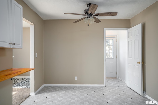 unfurnished room featuring ceiling fan and a textured ceiling