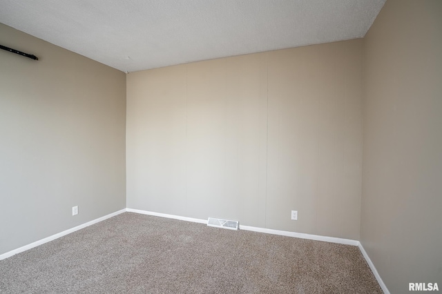 carpeted empty room with a textured ceiling