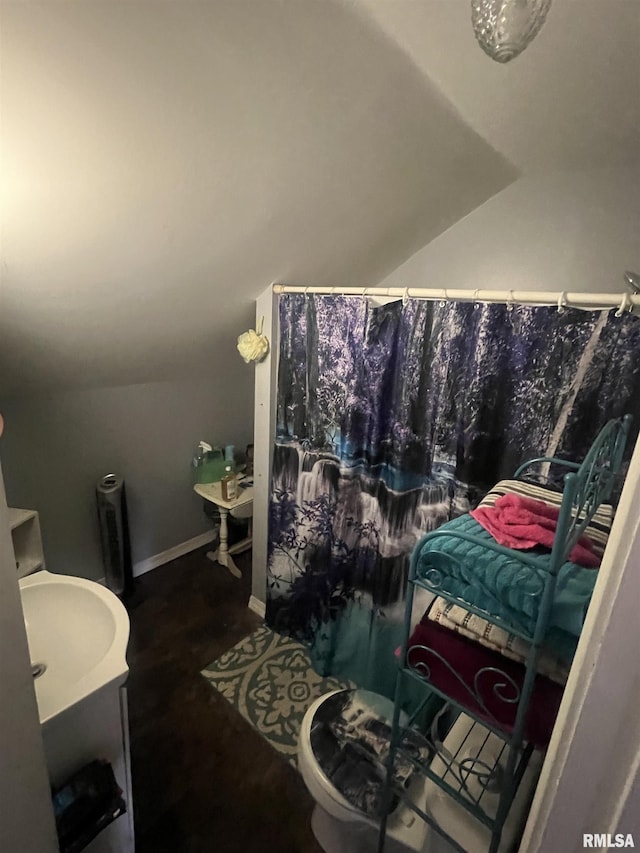 bathroom with a shower with shower curtain and lofted ceiling