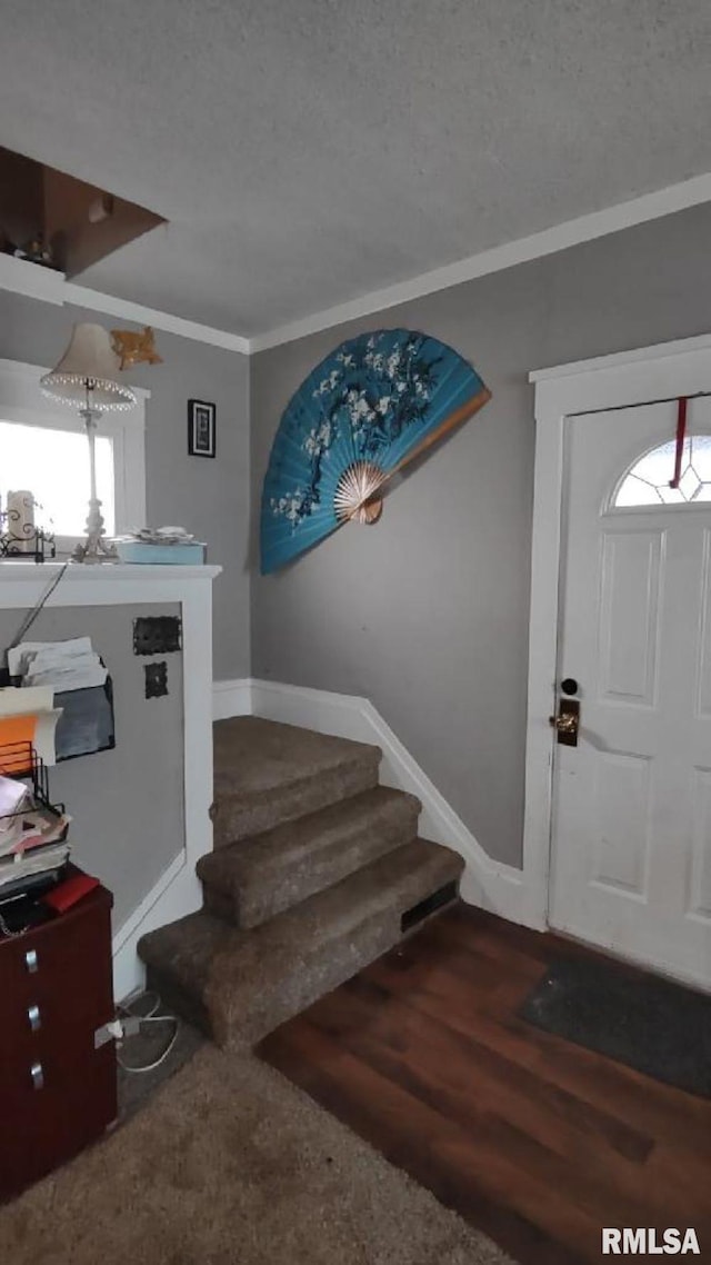 entrance foyer featuring hardwood / wood-style floors, crown molding, and a textured ceiling