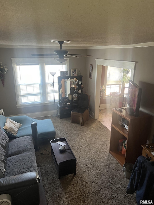 living room featuring crown molding, ceiling fan, carpet floors, and a wealth of natural light