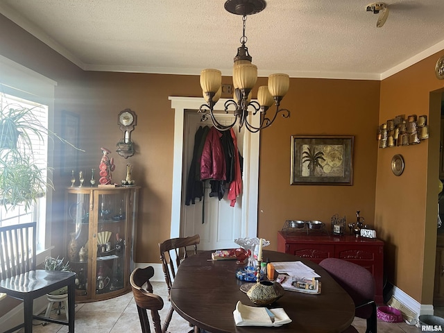 dining room with light tile patterned floors, ornamental molding, a textured ceiling, and a chandelier
