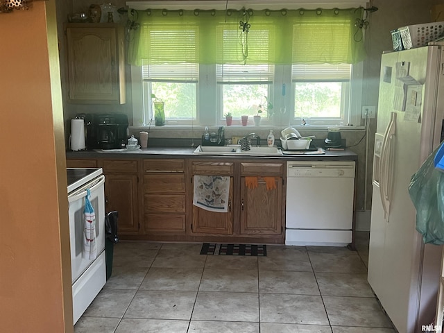 kitchen featuring a sink, light tile patterned floors, and white appliances