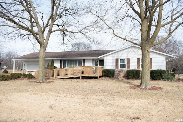 ranch-style home featuring a garage, a front yard, and a deck