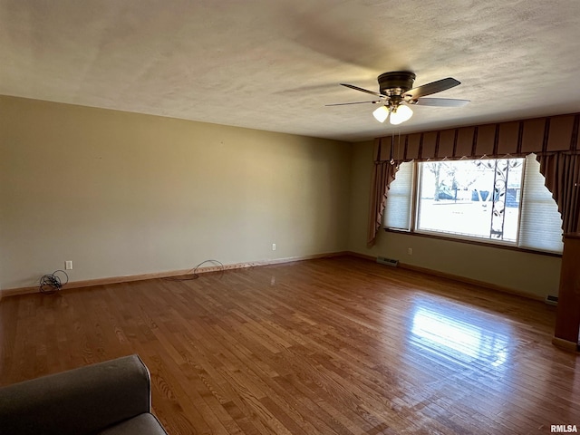 unfurnished room featuring hardwood / wood-style flooring, ceiling fan, and a textured ceiling