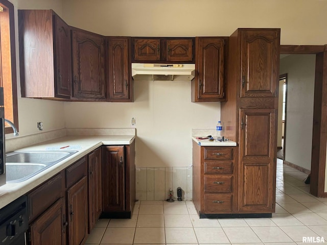 kitchen with black dishwasher, sink, light tile patterned floors, and dark brown cabinets