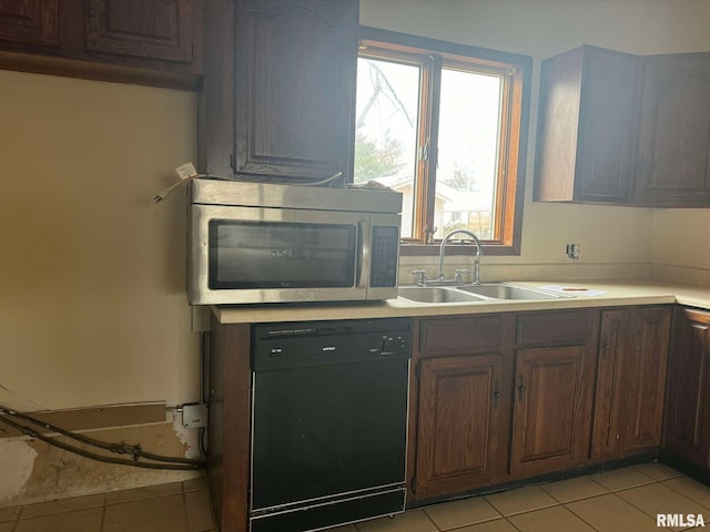 kitchen featuring dishwasher, sink, light tile patterned flooring, and dark brown cabinetry