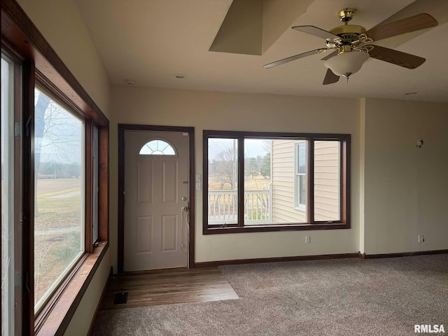 carpeted entrance foyer featuring a wealth of natural light and ceiling fan