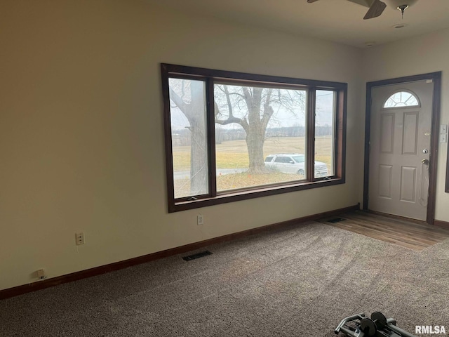 carpeted foyer entrance featuring ceiling fan