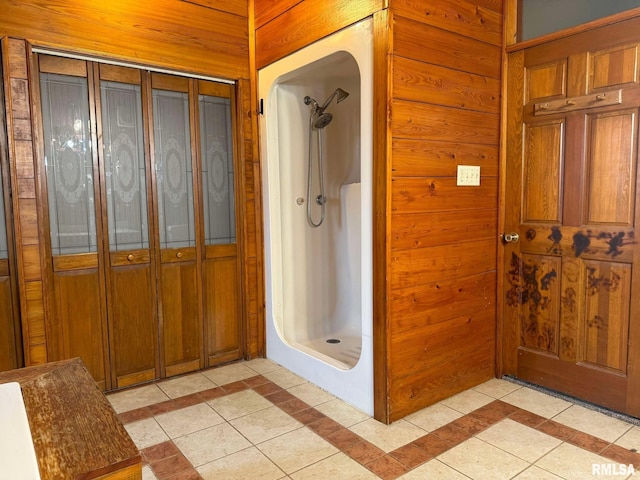 bathroom with walk in shower, tile patterned floors, and wood walls