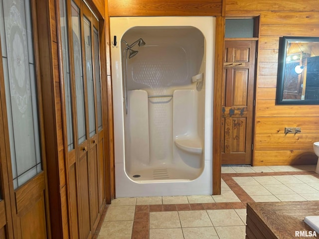 bathroom featuring walk in shower, tile patterned floors, vanity, and wooden walls