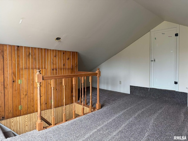 bonus room with wooden walls, lofted ceiling, and carpet flooring