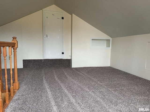 bonus room featuring lofted ceiling and dark colored carpet